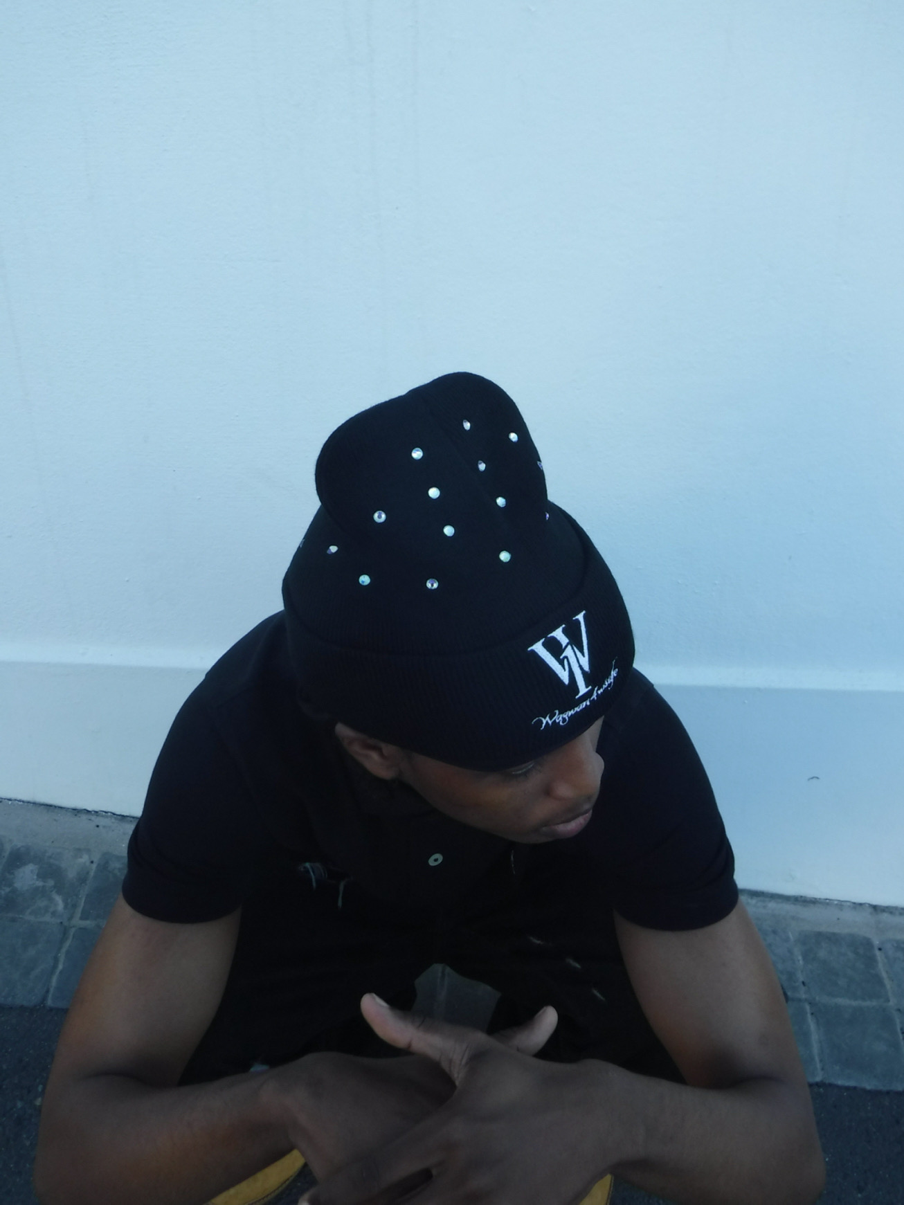 Close portrait of a person wearing a black WANOFWAN beanie