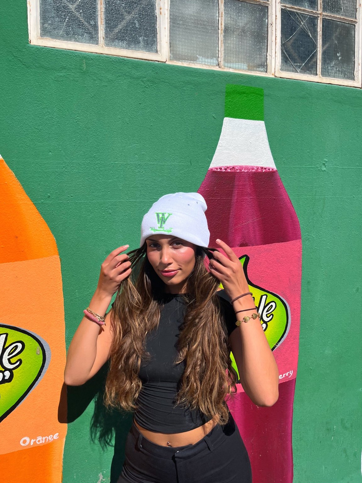 White beanie, front view in a colourful street setting